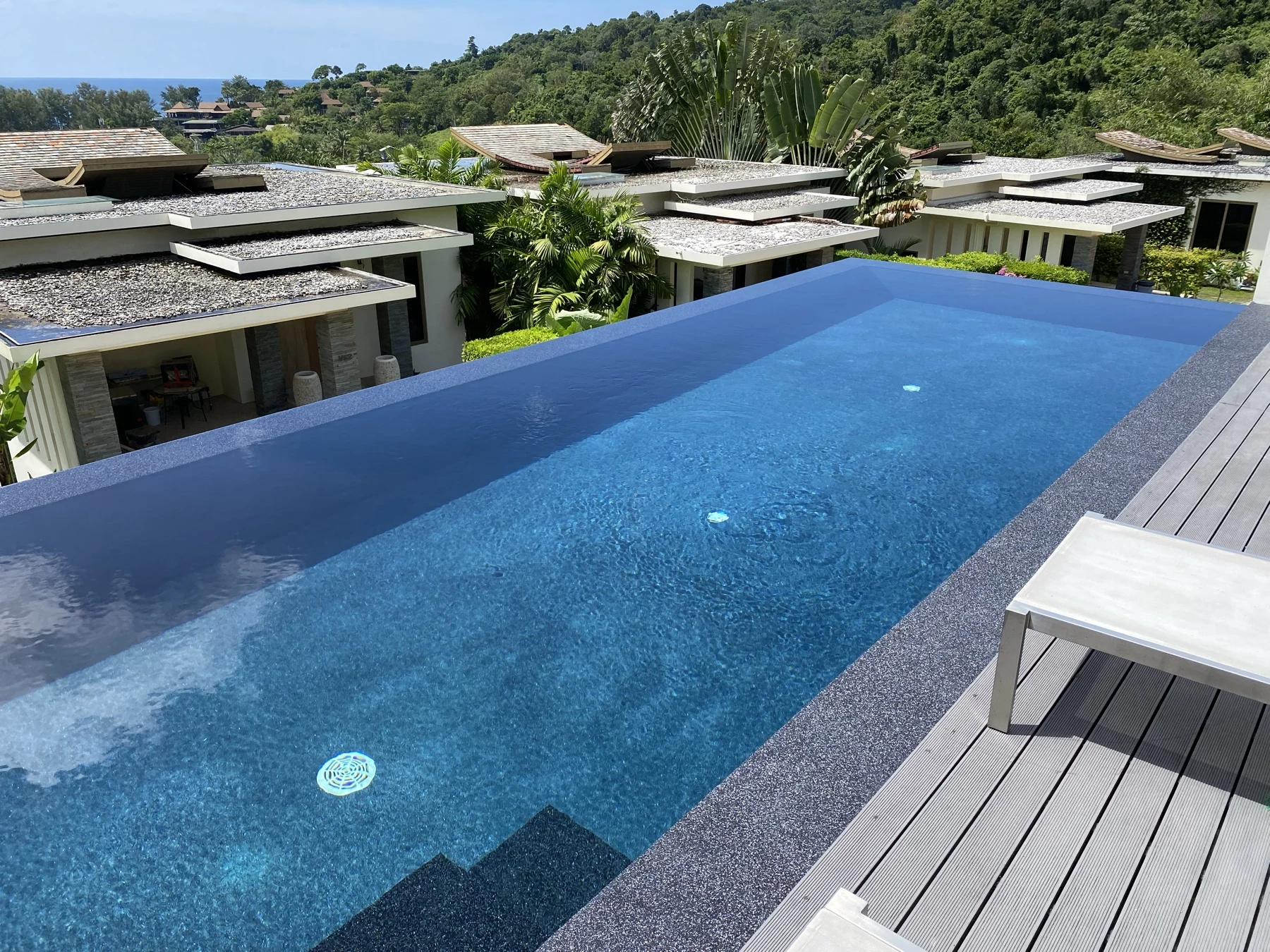 Overflow pool finished in PebbleCrete Supreme Royal Blue with an Nightfall Pearl surround at a private villa near Naithon Beach, Phuket