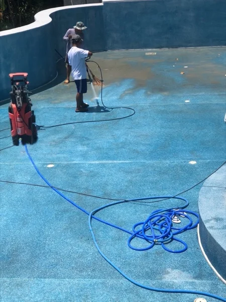 Washing the pool down with a pressure lance before the new surround was laid