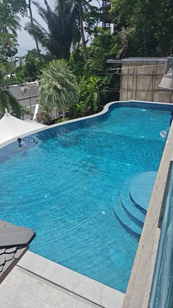 Cleaning the pool, with the Thai sala and the garden beyond