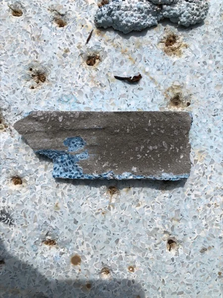A cut through the old surround showing the failed surface above the pool edge