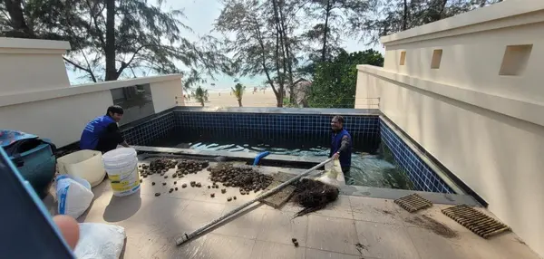 Beachfront Villa, Laguna — clearing the decorative pebbles out of the overflow channel