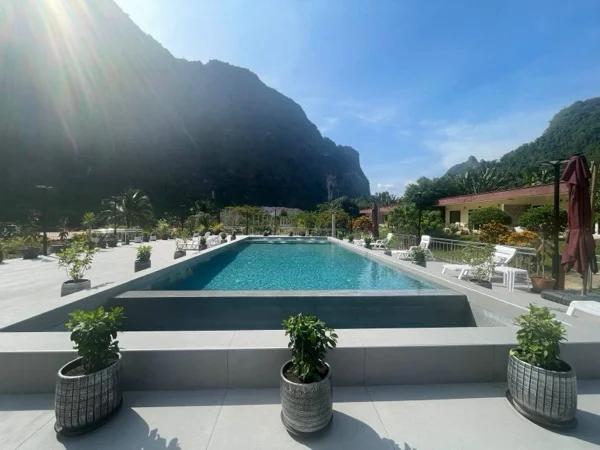 The pool and its paved terrace, with planters along the edge and the mountains beyond