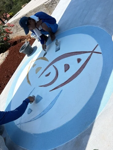 Setting the coloured aggregate of the resort logo by hand, piece by piece
