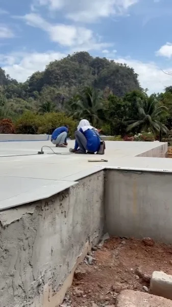 The coping and deck laid along the new pool, the limestone karst behind