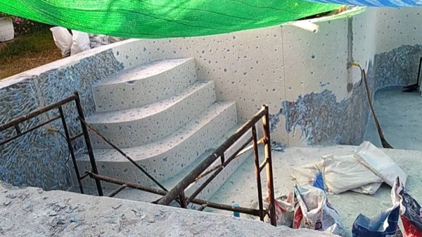 Material broken off the steps and the wall lying in the pool during the strip-out