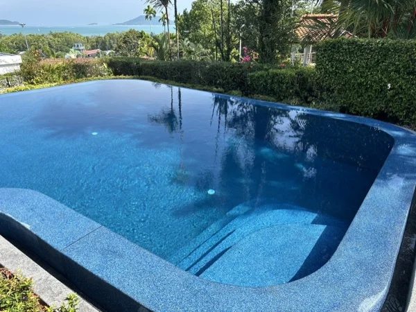The renovated pool with the bay and islands beyond the hedge at Cape Yamu