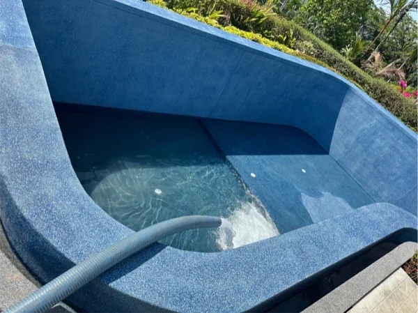 Water running into the finished pool through a hose after the Riviera Pearl finish was laid
