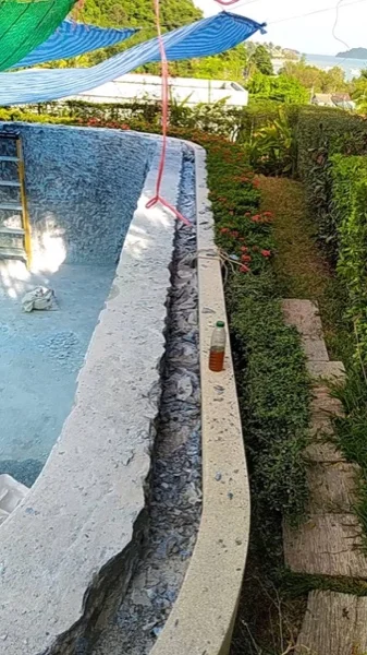 The raised spillway wall stripped of its old finish along the whole length