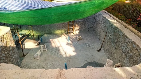 Broken-out material across the floor of the pool during the strip-out