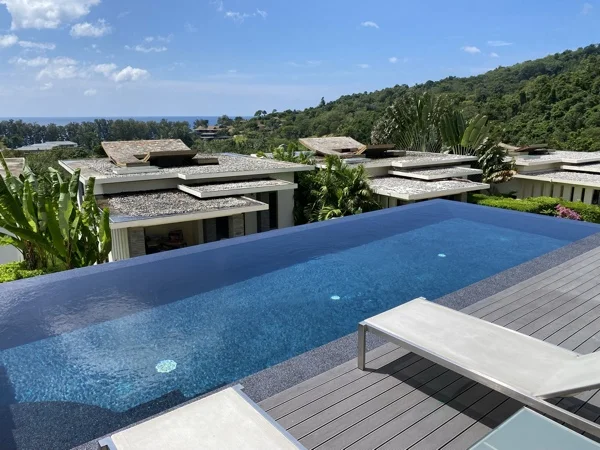 The pool and sun lounger on the timber deck, looking out over the estate towards the coast