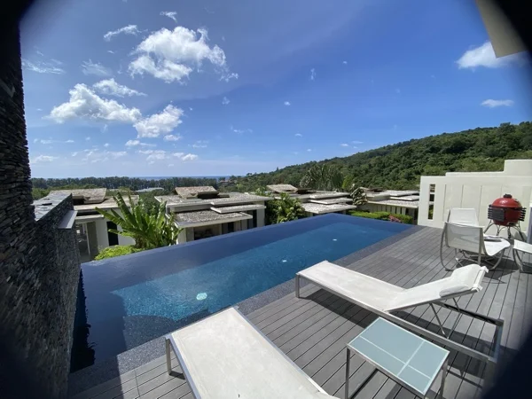 The stone-clad wall at the head of the pool, with the Nightfall Pearl surround and the terrace