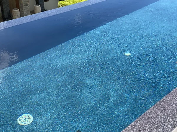 Sunlight on the water above the Royal Blue finish, with the dark speckled coping alongside