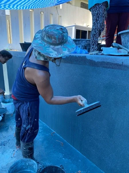 Sponging the freshly applied PebbleCrete Supreme finish back on the pool wall