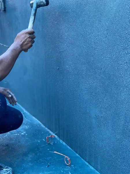 A float working the Royal Blue finish across the pool wall