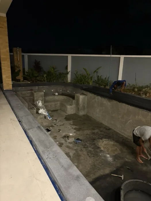 Private Villa, Pasak — the dark coping in place and the shell still grey, work going on after dark