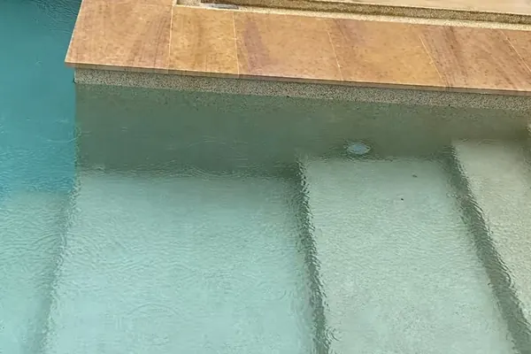 The Estate, Ao Po — the steps under clear water, sandstone coping above