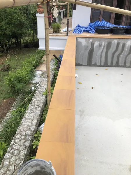 The Estate, Ao Po — sandstone coping along the rendered shell