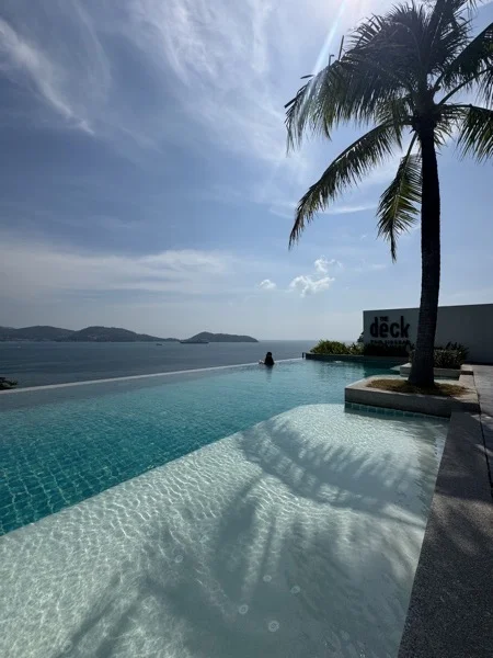 Wyndham Grand Phuket Kalim Bay — the PebbleCrete tanning ledge, the infinity pool and the sea beyond