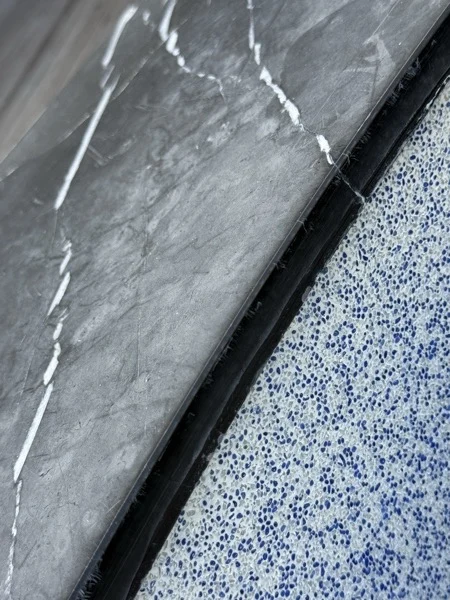 Zima Spa & Wellness — blue glass beads meeting the dark coping