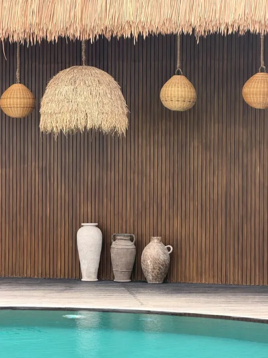 Main pool water beside a timber wall and pendant lamps at ZIMA Spa