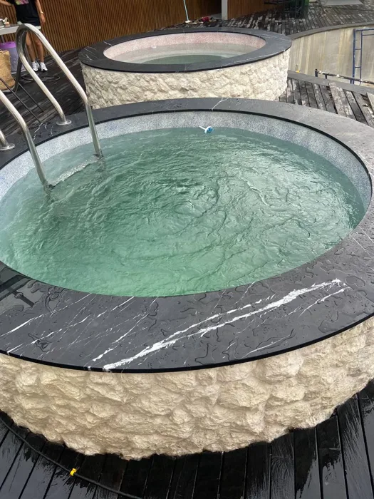 Two circular plunge pools at ZIMA Spa with contrasting custom PebbleCrete Supreme finishes