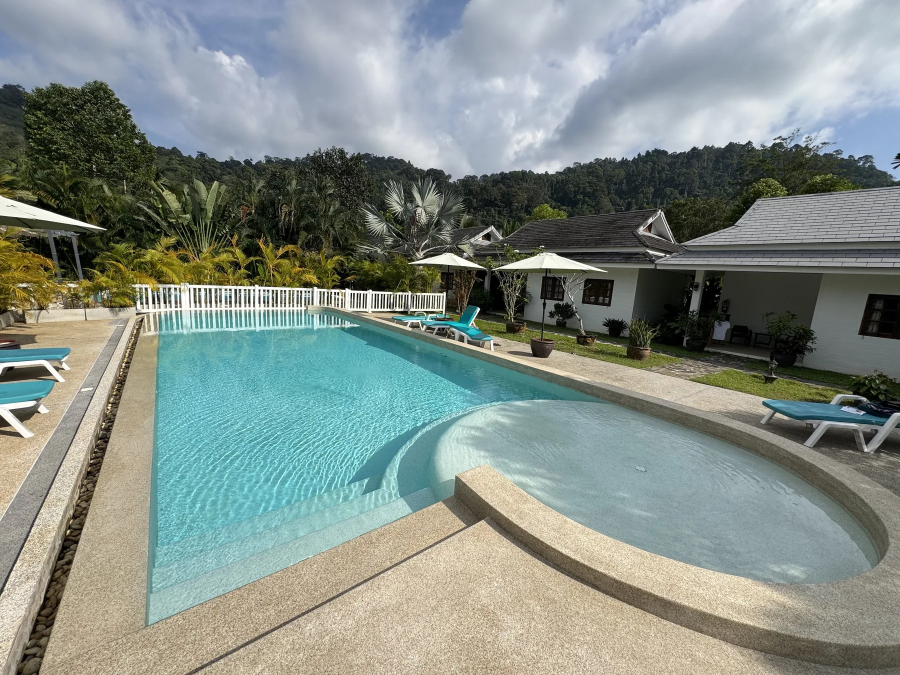 Villa Colina, Khao Lak — the renewed pool and its curved shallow ledge, with the guesthouse beyond
